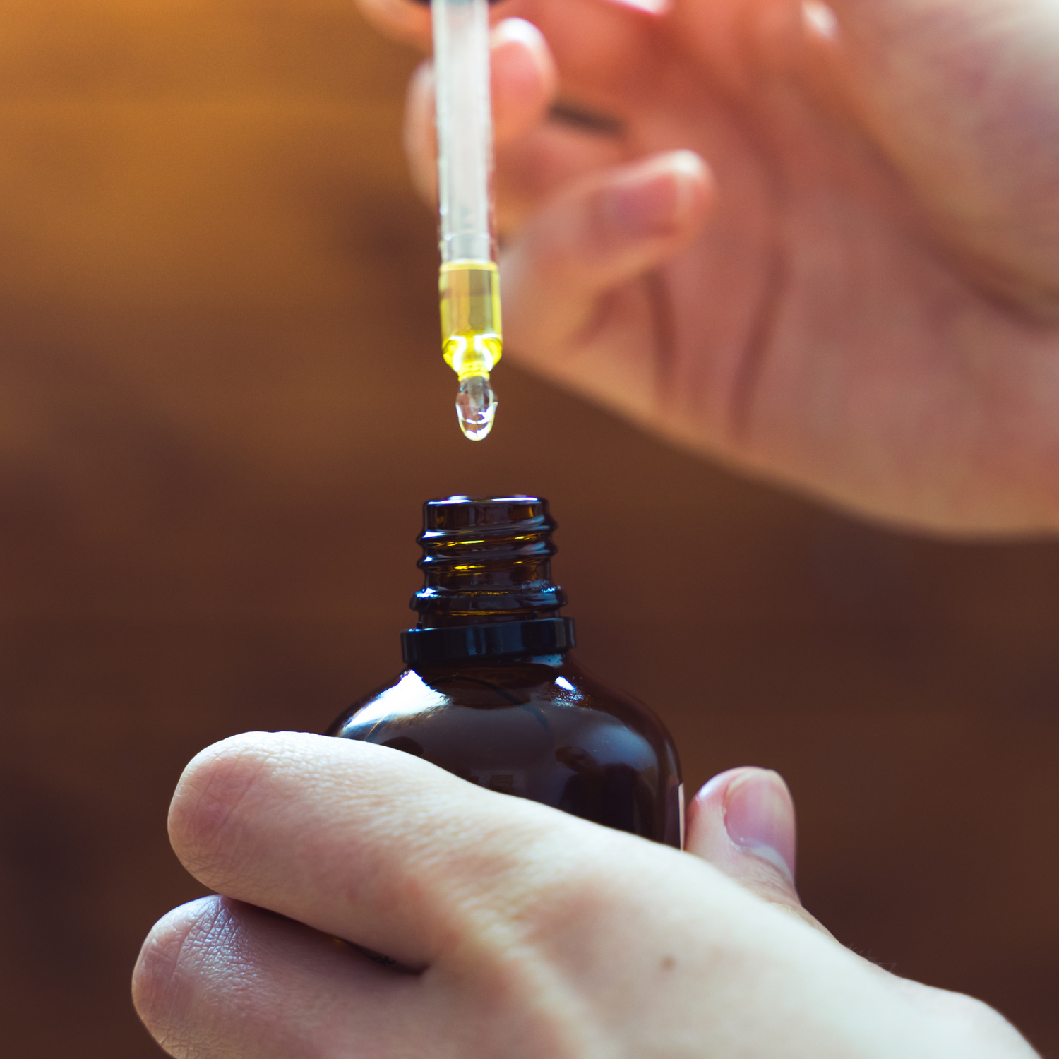 hands holding cbd tincture dropper